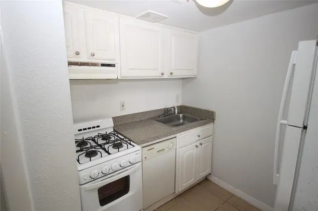 a white stove top oven sitting inside of a kitchen
