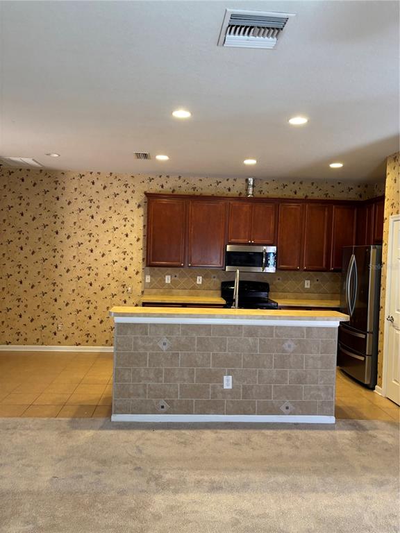 13719 Eastfork Lane Hudson, FL 34669 - Photo 4 of 17 a living room with stainless steel appliances kitchen island granite countertop a couch and a view of kitchen