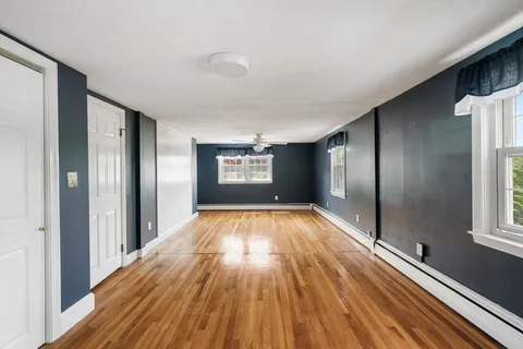 an empty room with window and wooden floor