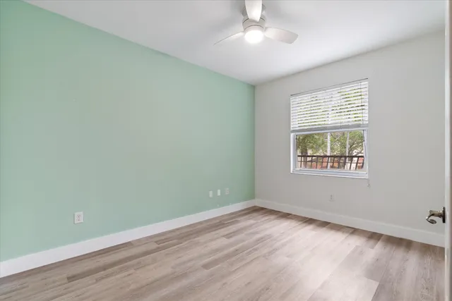an empty room with wooden floor and windows