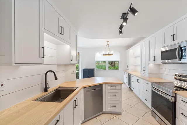 a kitchen with stainless steel appliances a sink stove and cabinets