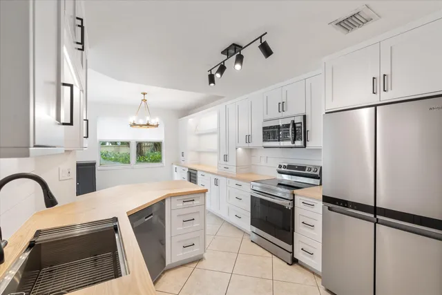 a kitchen with stainless steel appliances a stove refrigerator sink and cabinets