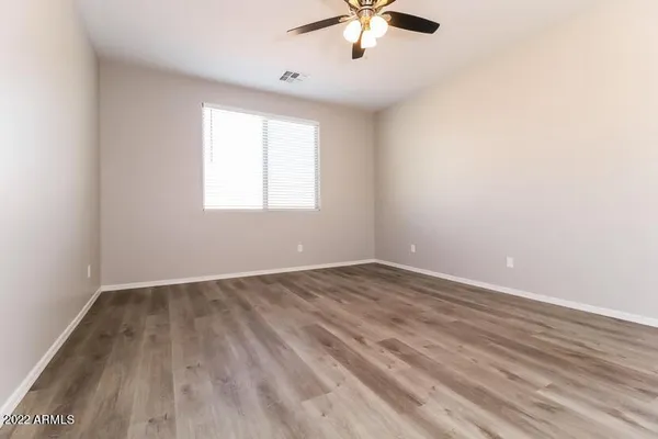 an empty room with a window and a ceiling fan