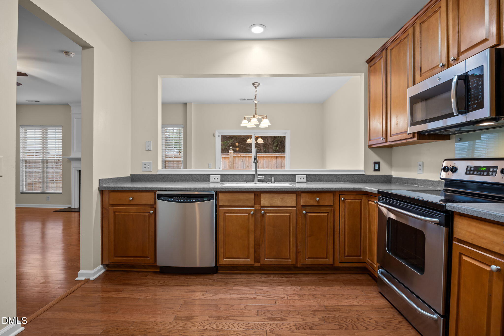 7805 Jeffrey Alan Court Raleigh, NC 27613 - Photo 14 of 46 a kitchen with stainless steel appliances granite countertop a sink a stove a microwave and wooden cabinets