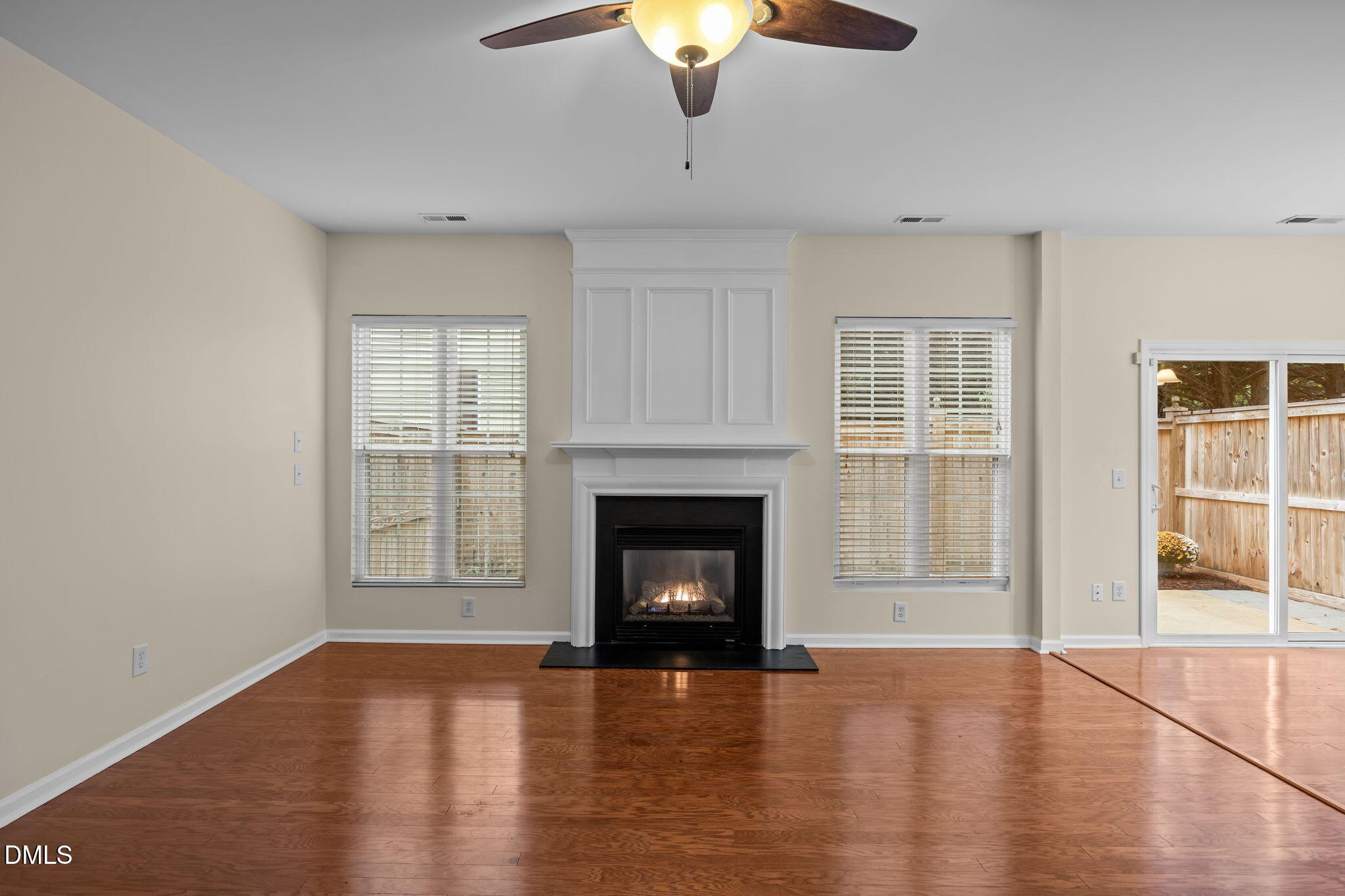 7805 Jeffrey Alan Court Raleigh, NC 27613 - Photo 8 of 46 a view of an empty room with wooden floor fireplace and a window