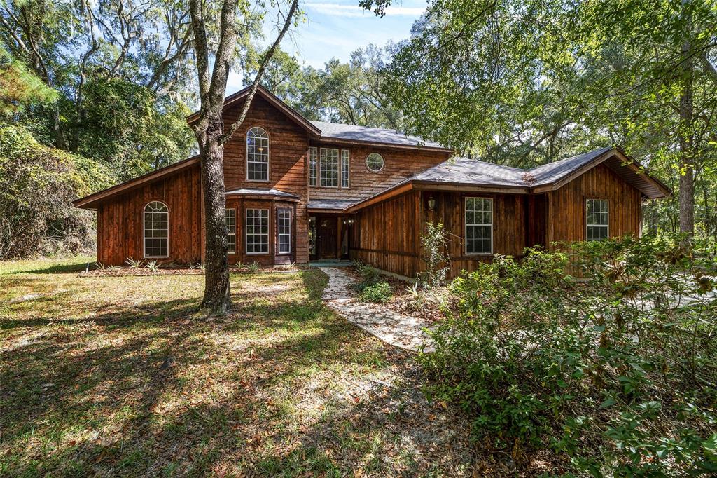 14211 Southwest 70 Street Archer, FL 32618 - Photo 1 of 1 a view of a yard in front of a house with a large tree