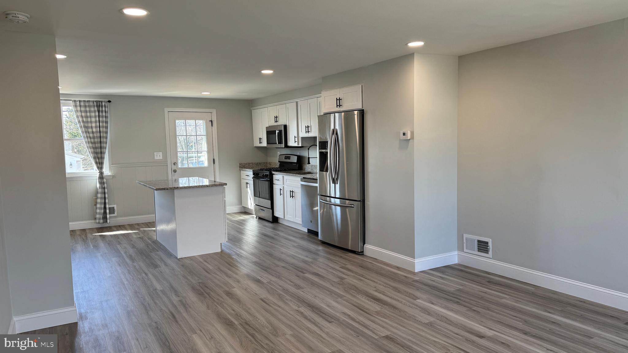 8029 Stratman Road Dundalk, MD 21222 - Photo 5 of 41 a view of kitchen with refrigerator stove and wooden floor