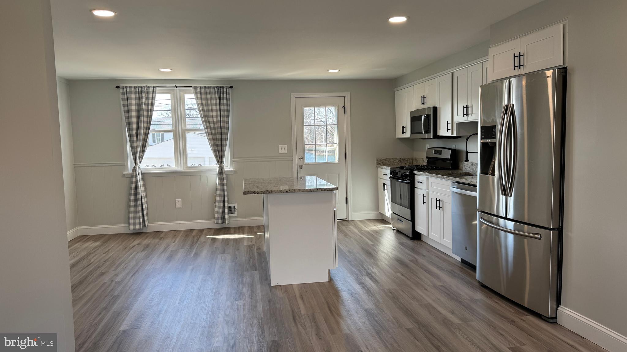 8029 Stratman Road Dundalk, MD 21222 - Photo 6 of 41 a kitchen with a refrigerator a sink and wooden floor
