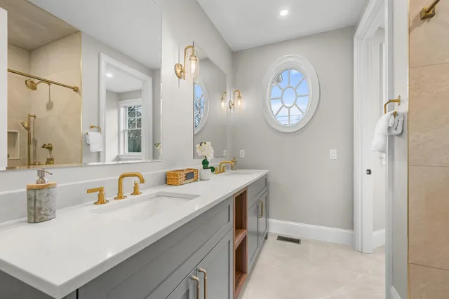 a bathroom with a shower sink vanity and mirror