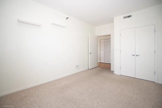 an empty room with windows and closet