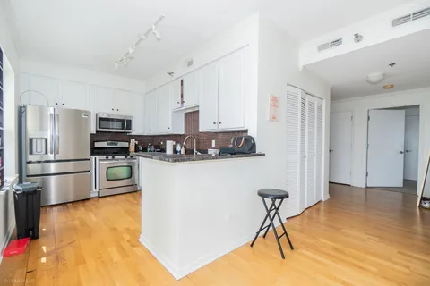 a kitchen with granite countertop a white stove top oven and refrigerator