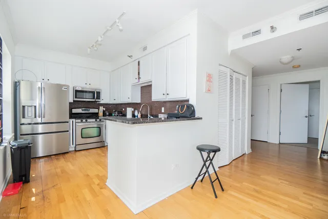 a kitchen with granite countertop a white stove top oven and refrigerator