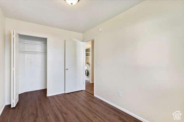 947 Canyon Road South, Unit 15 Ogden, UT 84404 - Photo 13 of 22 Unfurnished bedroom with dark wood-style flooring, a closet, and washer / clothes dryer