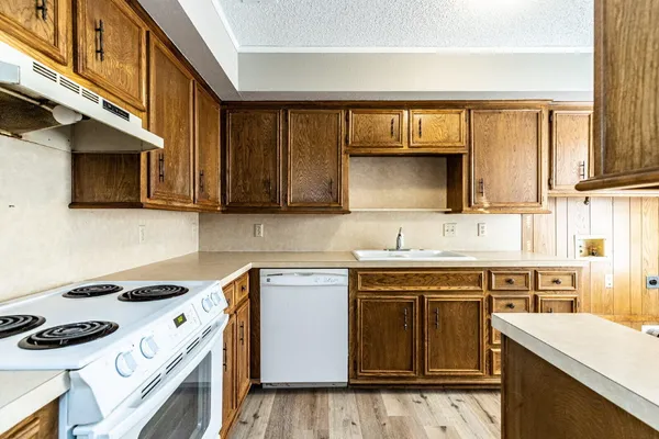a kitchen with a sink stove top oven and cabinets
