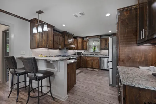 a bathroom with a granite countertop sink a toilet and a mirror