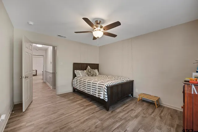a bedroom with a bed and a ceiling fan