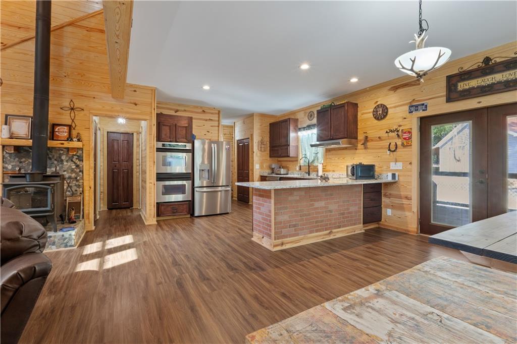 661 Wildcat Road Buchanan, GA 30113 - Photo 23 of 51 a kitchen with stainless steel appliances kitchen island granite countertop a refrigerator a oven a stove and a sink with wooden floor