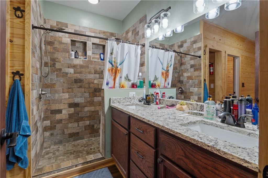 661 Wildcat Road Buchanan, GA 30113 - Photo 31 of 51 a bathroom with a granite countertop sink a mirror and shower
