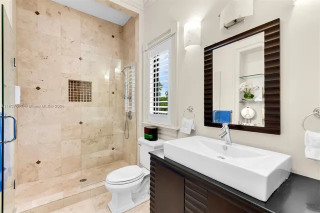 a bathroom with a granite countertop toilet a sink a mirror and a bathtub