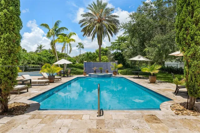 a view of a house with a yard and palm trees