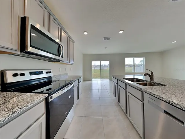 a kitchen with stainless steel appliances granite countertop a sink and stove top oven