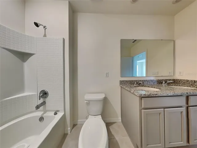 a bathroom with a granite countertop sink toilet and bathtub