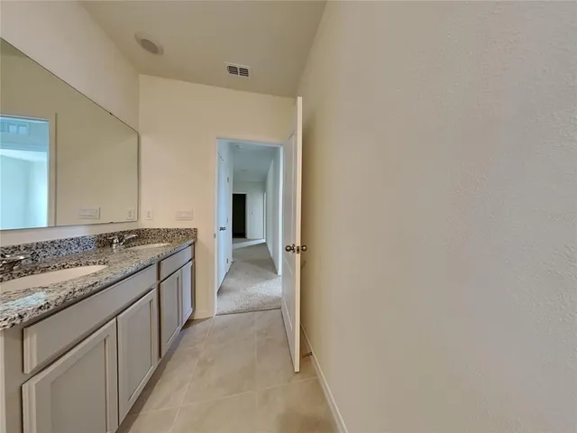a large bathroom with a granite countertop sink and a mirror