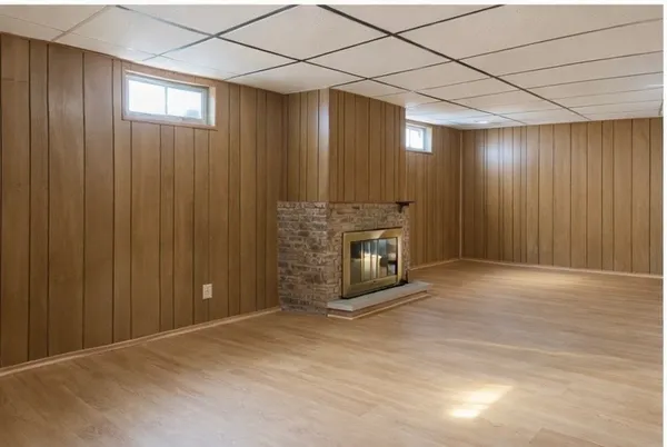 an empty room with windows & cabinet and mirrors
