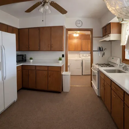 a kitchen with stainless steel appliances a sink a stove a refrigerator cabinets and a counter top space