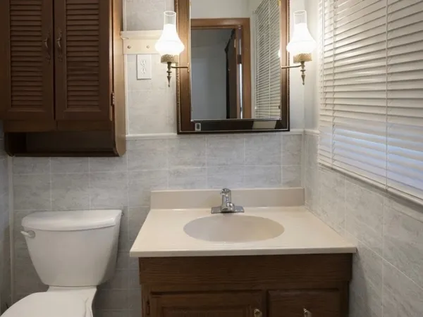 a bathroom with a toilet sink and mirror