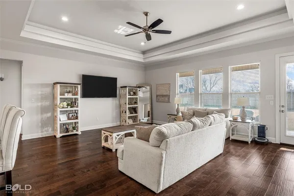 a living room with furniture and a flat screen tv with wooden floor