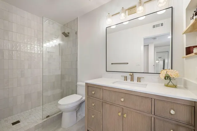 a bathroom with a sink a toilet and shower