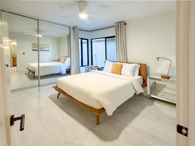 a bedroom with a bed and a large mirror