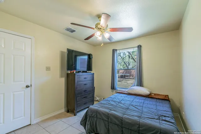 a bedroom with a bed and a ceiling fan