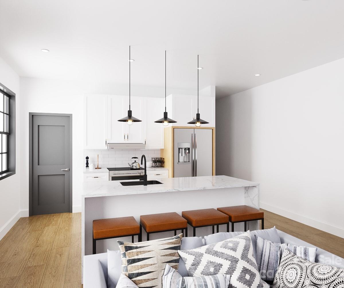 203 Grandin Road, Unit 3 Charlotte, NC 28208 - Photo 4 of 6 a kitchen with stainless steel appliances kitchen island granite countertop a refrigerator a stove and a sink with wooden floor