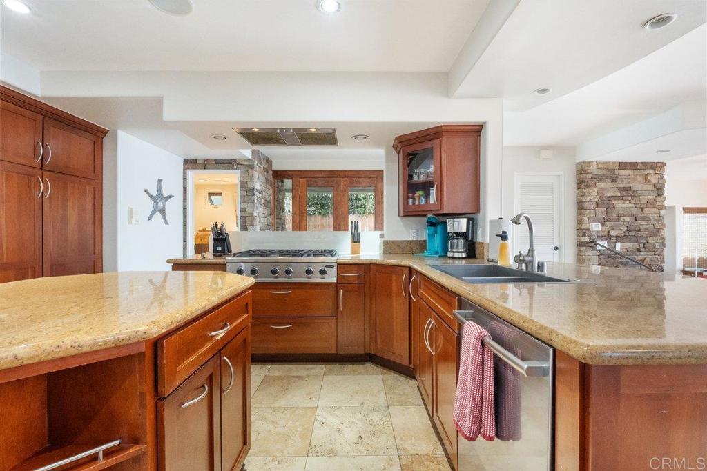 378 Neptune Avenue Encinitas, CA 92024 - Photo 20 of 45 a large kitchen with kitchen island granite countertop a sink and dishwasher a stove with wooden cabinets