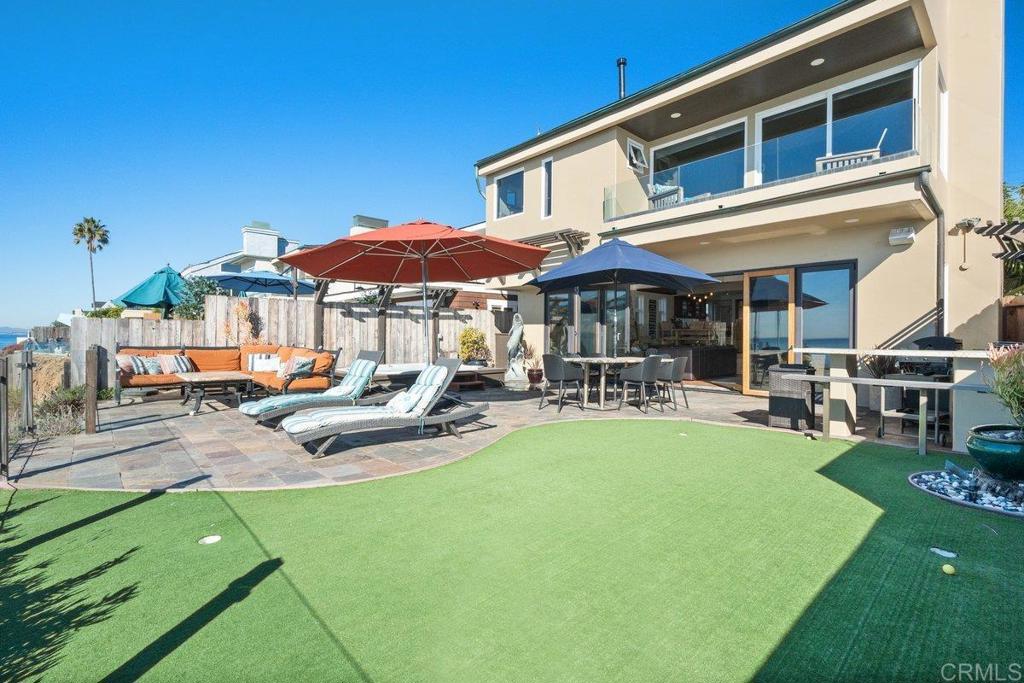 378 Neptune Avenue Encinitas, CA 92024 - Photo 3 of 45 a patio with a table and chairs under an umbrella