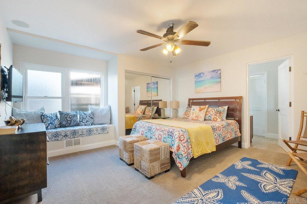 378 Neptune Avenue Encinitas, CA 92024 - Photo 38 of 45 a bedroom with a large bed and a chandelier