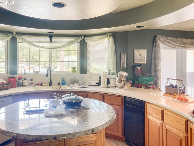 a kitchen with a granite countertop sink and a stove