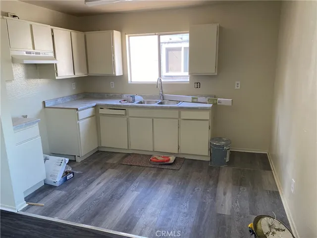 a kitchen with sink cabinets and wooden floor