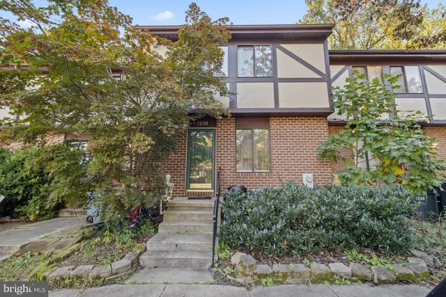 a front view of a house with plants and trees