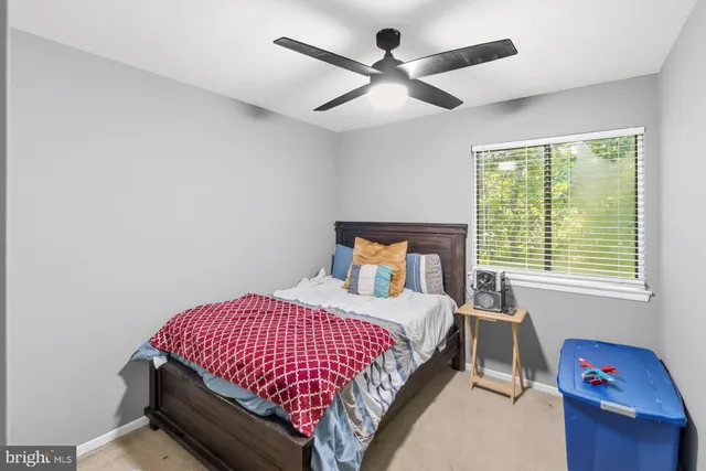 a bedroom with a bed and a chandelier fan