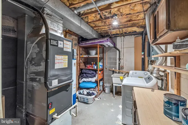 a view of a backyard with plants and large trees with wooden fence
