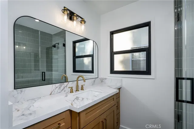 a bathroom with a granite countertop sink and a mirror