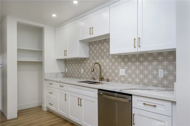 a kitchen with stainless steel appliances granite countertop a sink and a white cabinets