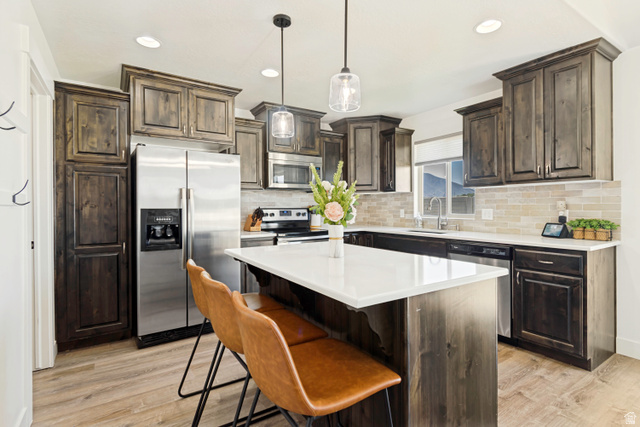983 West 1550th Street South Springville, UT 84663 - Photo 16 of 43 Kitchen featuring wood-finish cabinetry, stainless steel appliances, a center island with white countertop, and recessed lighting.