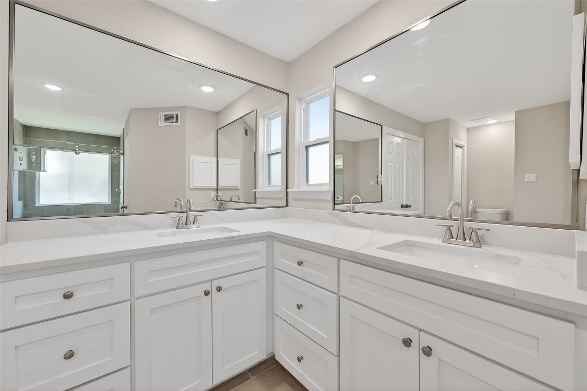 2318 Irish Spring Drive Houston, TX 77067 - Photo 16 of 25 a bathroom with double sink and a mirror
