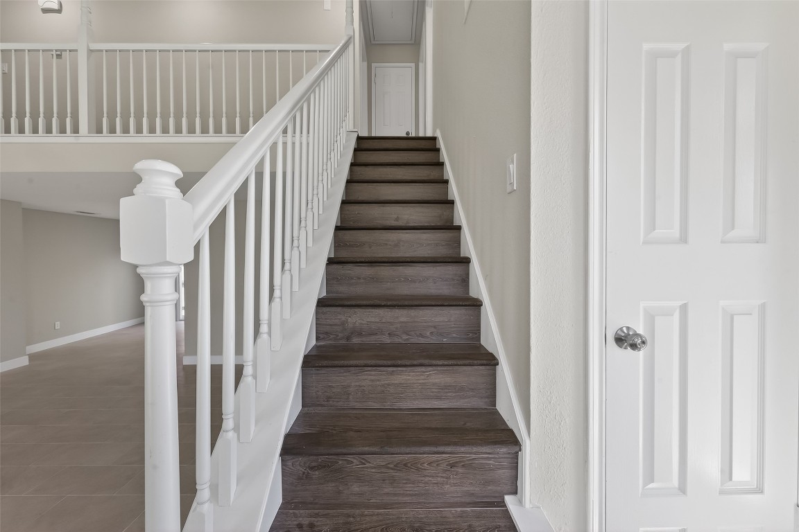 2318 Irish Spring Drive Houston, TX 77067 - Photo 17 of 25 a view of staircase with wooden floor and white walls