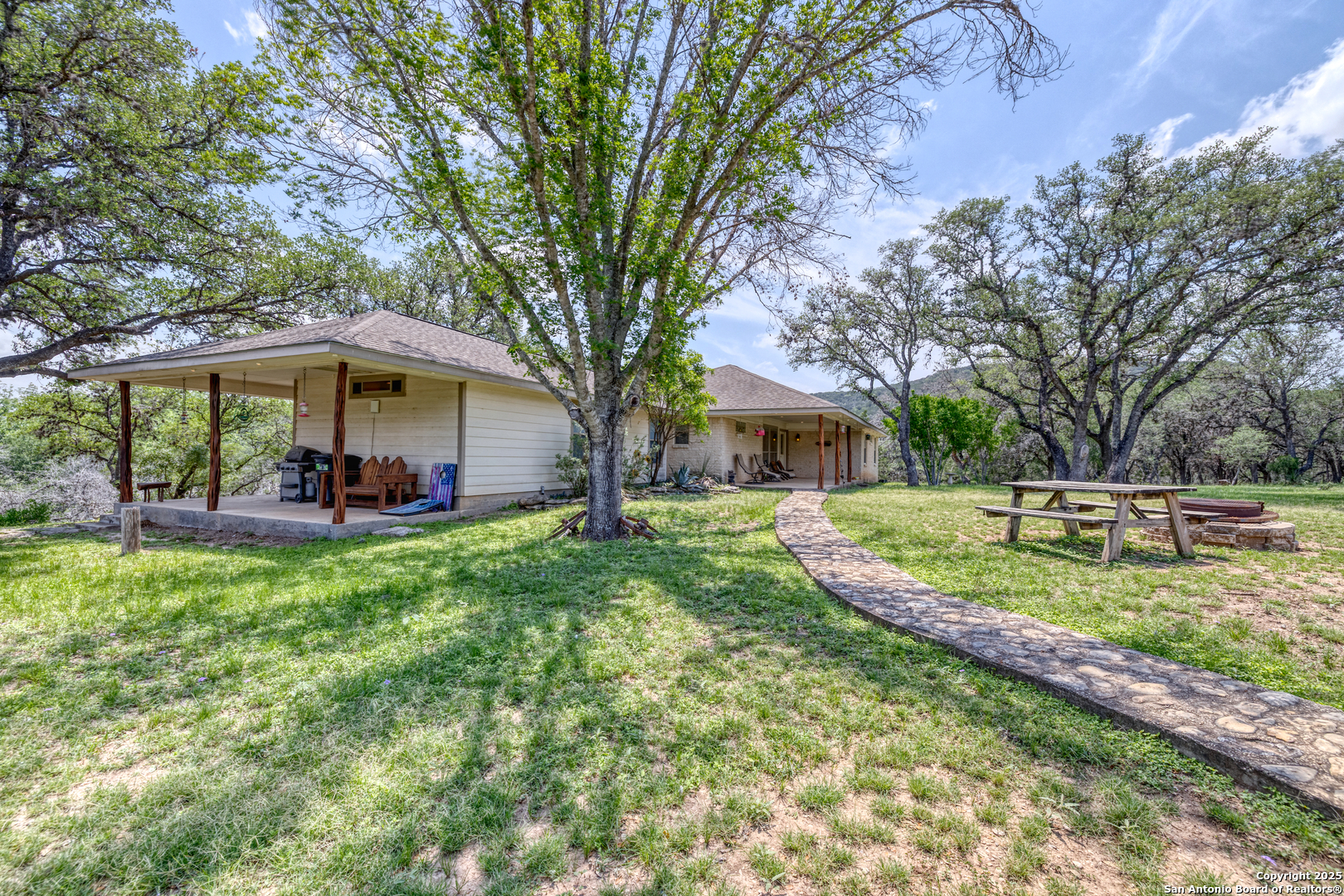 a view of a house with backyard and trees