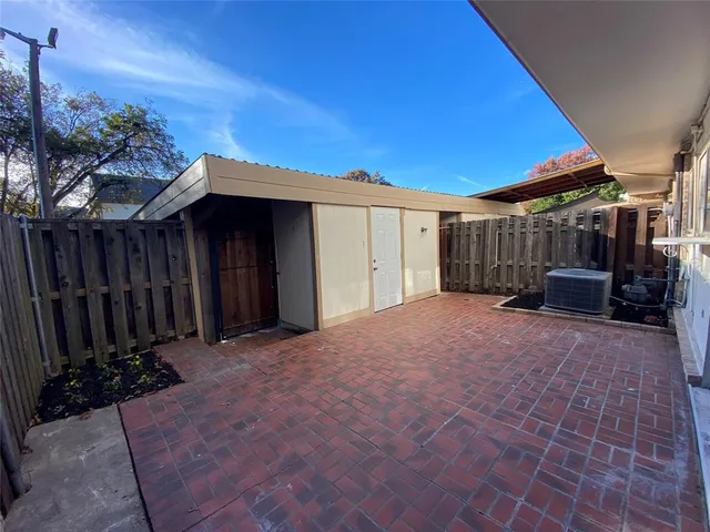 a view of backyard with potted plants and wooden fence